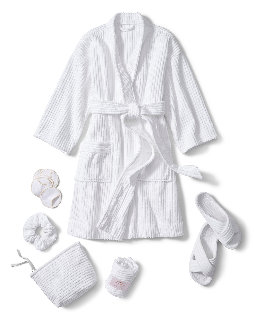 Soma<sup class=st-superscript>®</sup> laydown of a white spa robe, slippers, makeup bag, hair wrap, scrunchie, and makeup rounds.