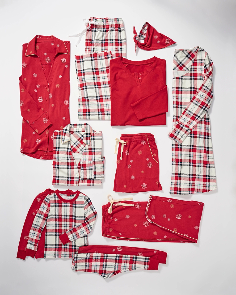 Soma<sup class=st-superscript>®</sup> laydown of solid red, red snowflake, and red and white plaid patterned pajamas + pet bandana.