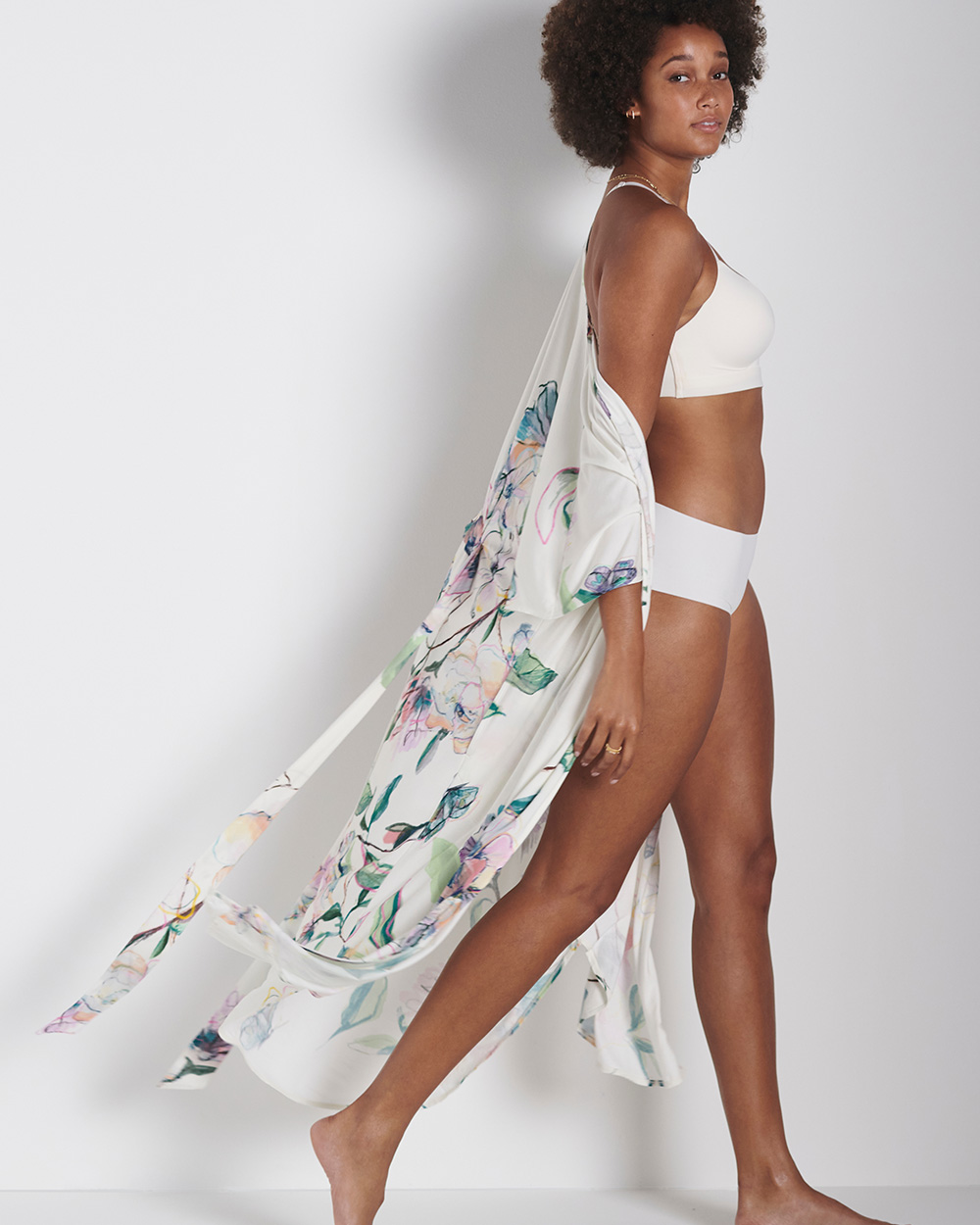 Soma<sup class=st-superscript>®</sup> model wearing a white bra and panties, and a long floral robe.