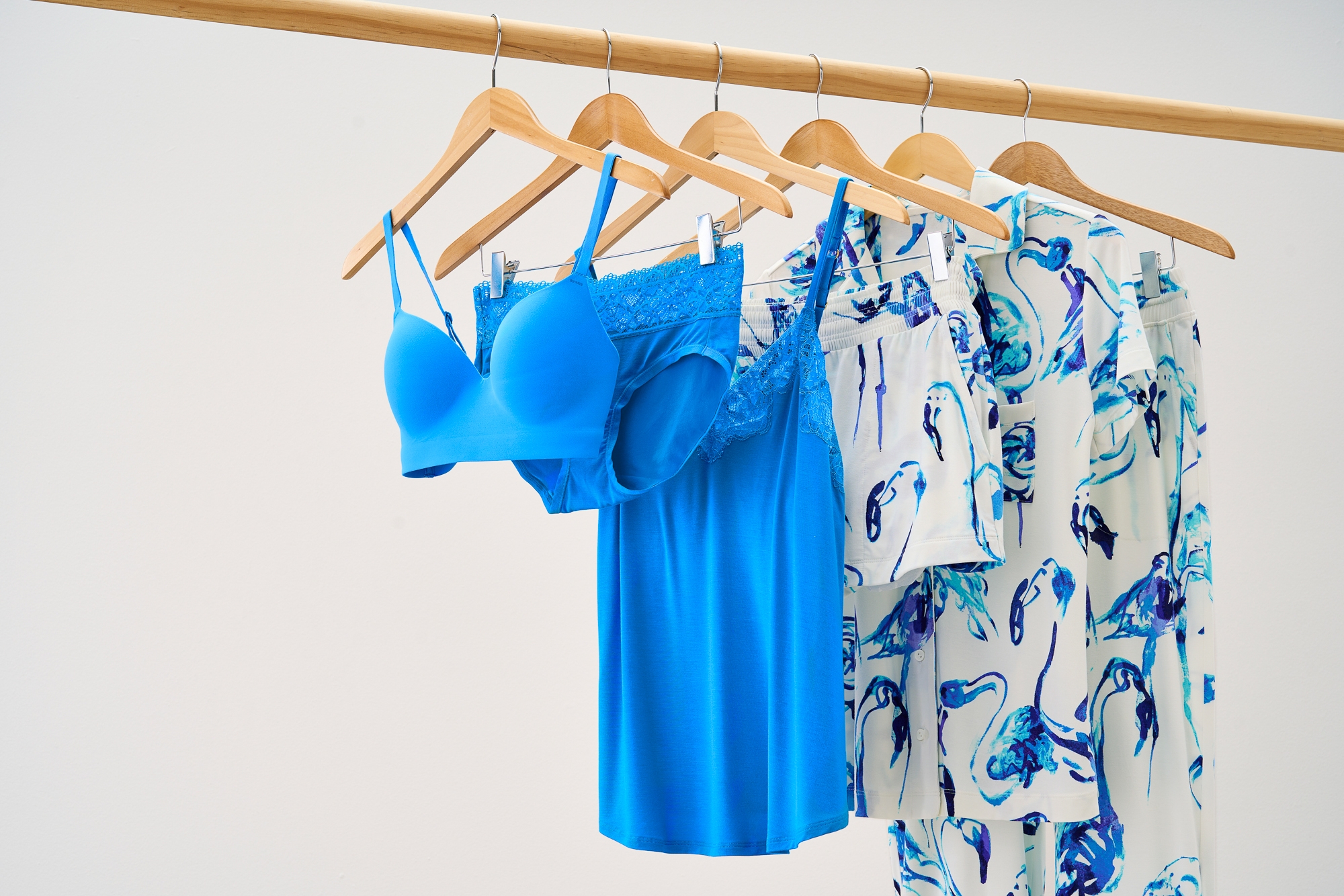 Soma<sup class=st-superscript>®</sup> women’s blue bra, panties, sleep cami and white and blue abstract printed pajamas hanging on a rack.