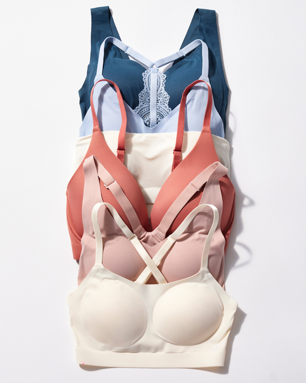 Soma<sup class=st-superscript>®</sup> laydown of soft wireless bras in dark blue, light blue, ivory, dark pink, and dusty pink.
