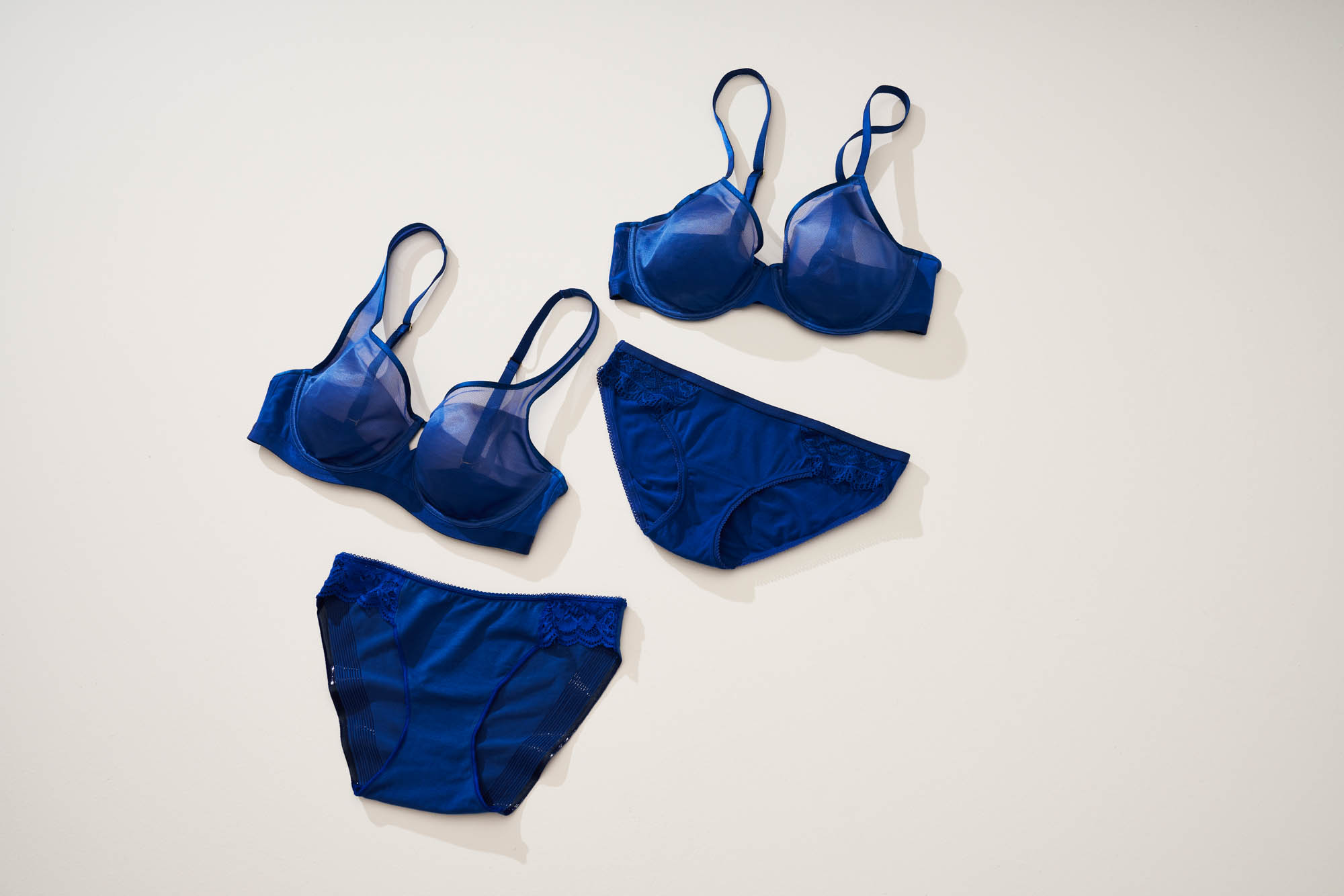Soma<sup class=st-superscript>®</sup> bridal lingerie laydown of dark blue unlined bras and hipster panties with lace.