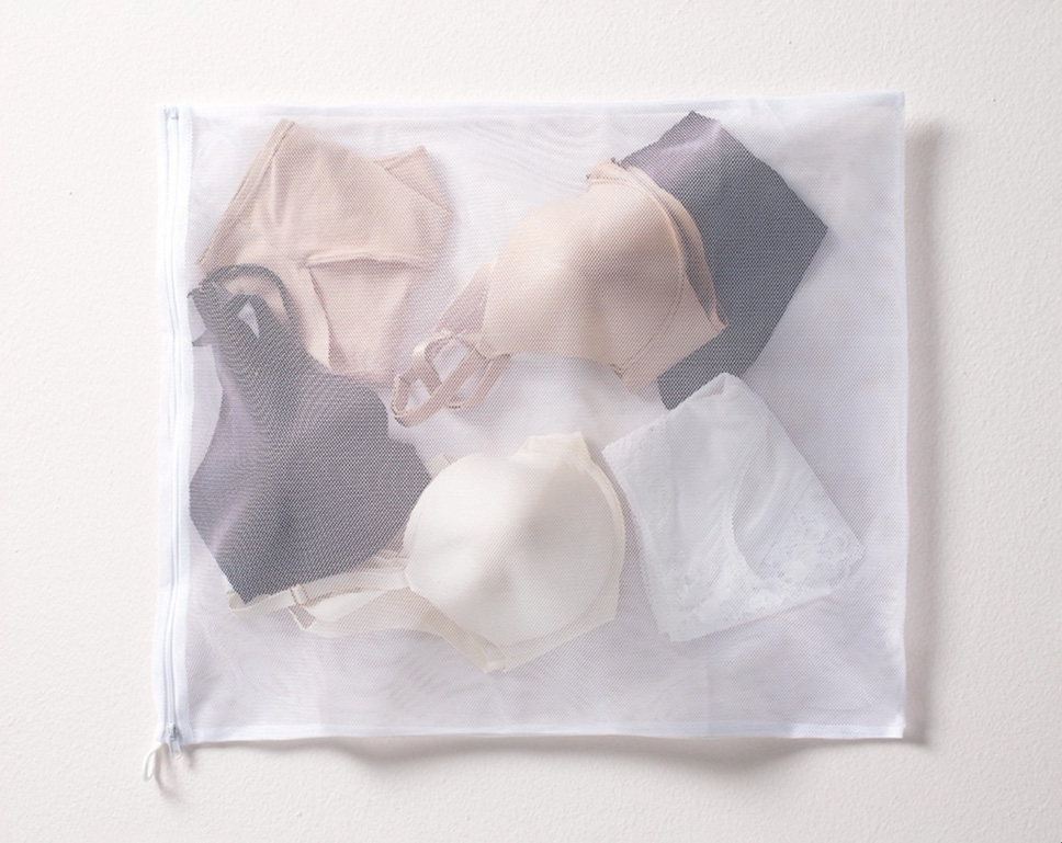 oma<sup class=st-superscript>®</sup> lingerie bag filled with black, white, and nude panties and bras. 