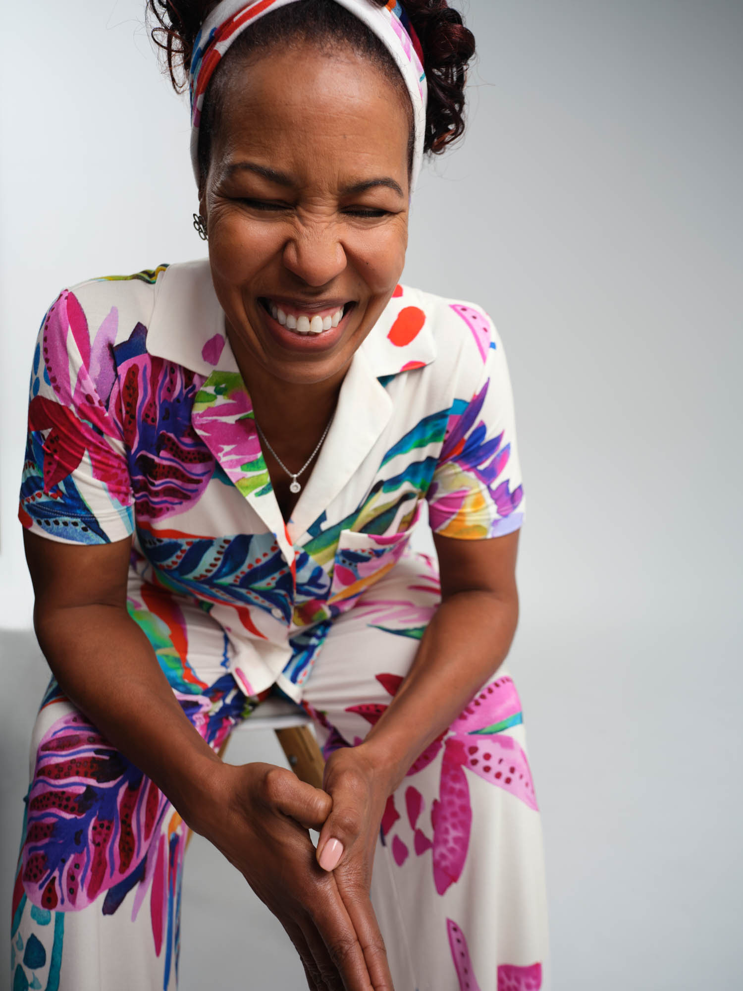 Soma women’s model wearing a colorful tropical notch collar pajama top, matching headband, and matching pajama bottoms.