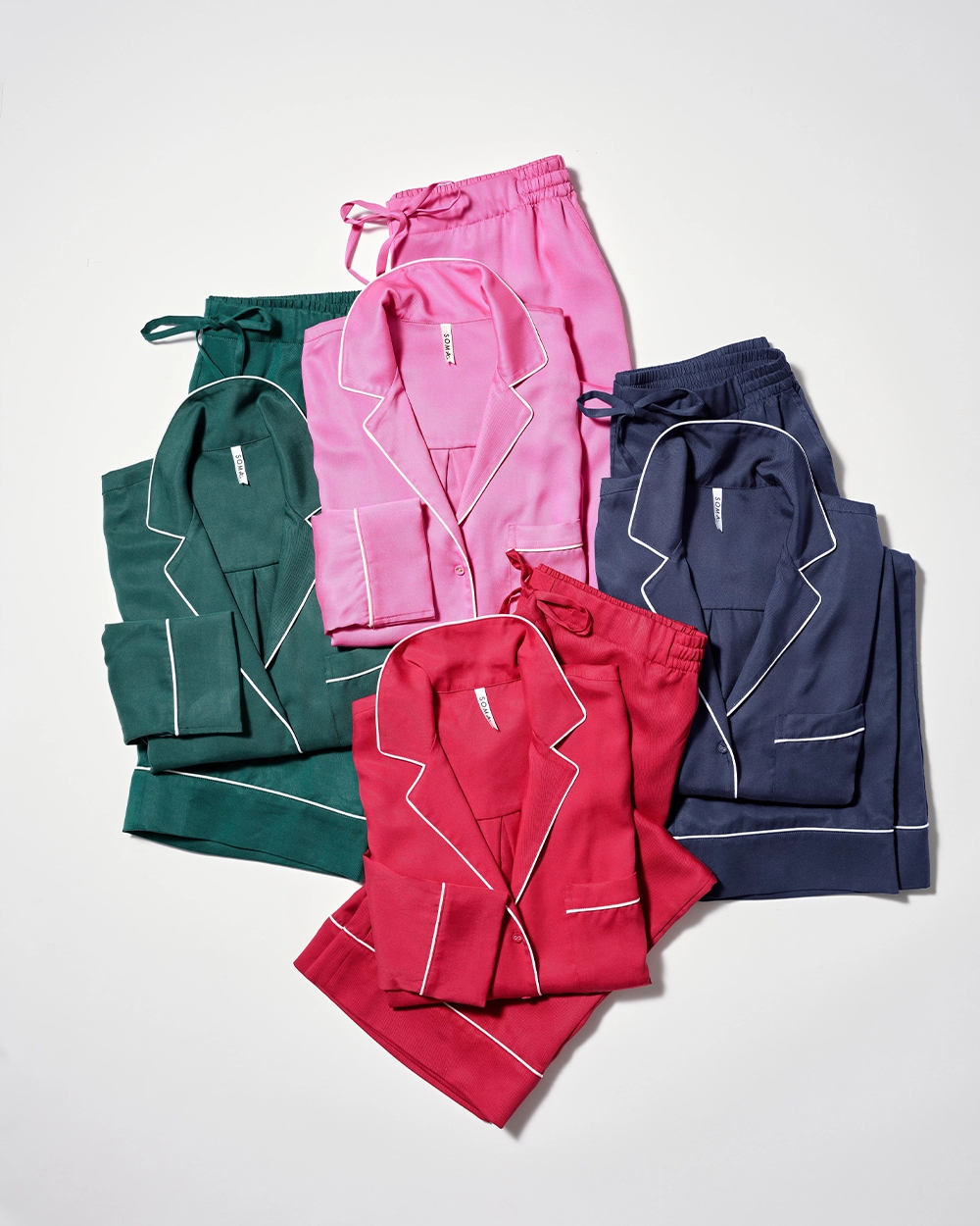Soma<sup class=st-superscript>®</sup> laydown of matching pajama sets in dark green, pink, red, and navy.