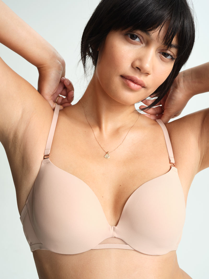 Soma<sup class=st-superscript>®</sup> women’s model wearing a nude bra and gold pendant necklace.