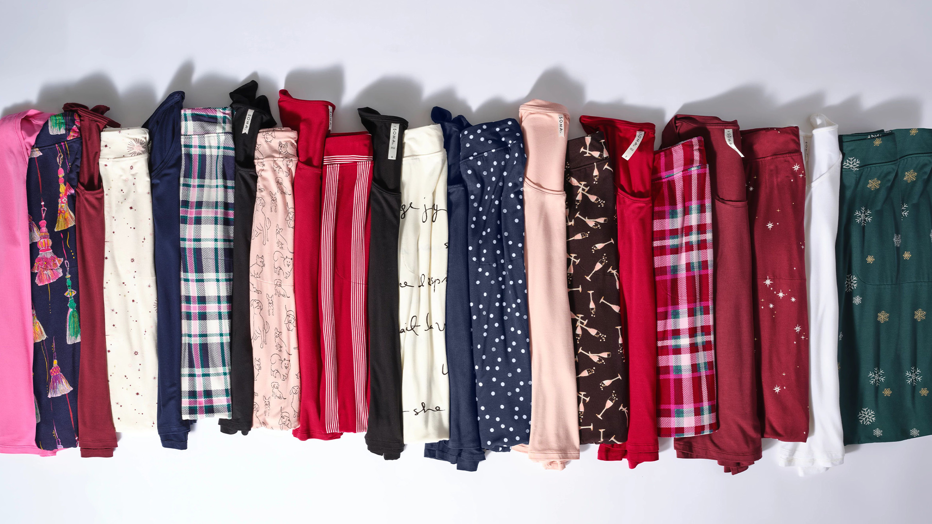 Soma<sup class=st-superscript>®</sup> laydown of stacked winter pajama tops and bottoms in an array of colors and neutrals and a variety of prints and solids.