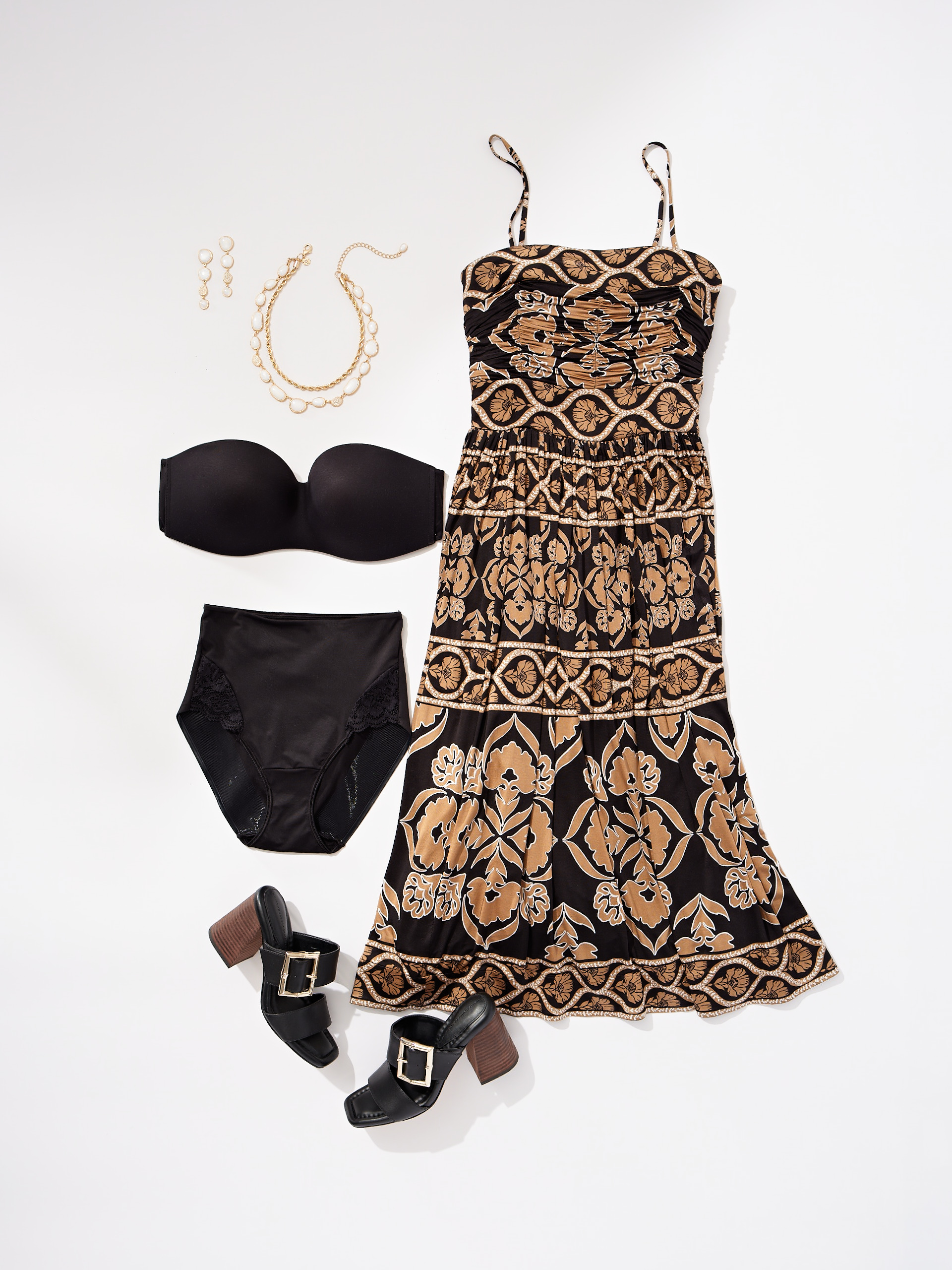 Soma<sup class=st-superscript>®</sup> laydown of a black bra and panties next to a WHBM dress, black shoes, and gold necklace and earrings. 
