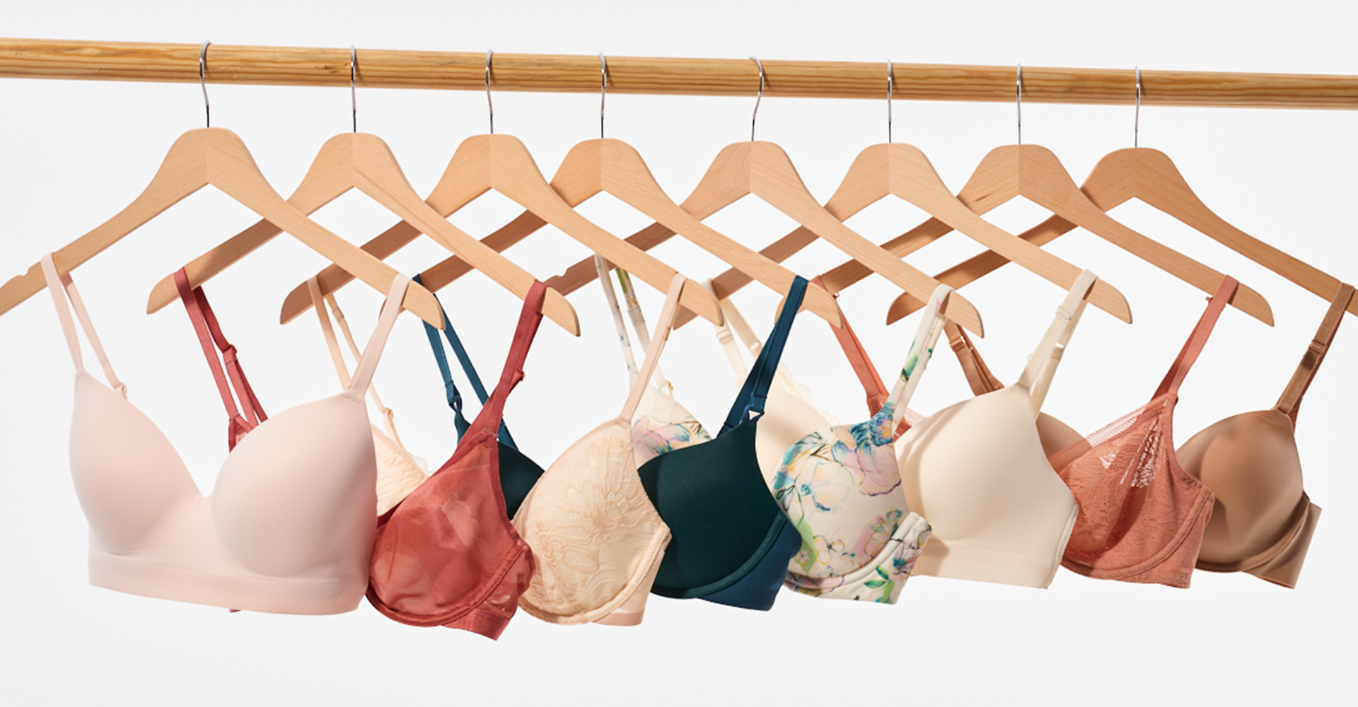 Soma<sup class=st-superscript>®</sup> bras in a variety of colors, prints, and styles hanging on a rack.