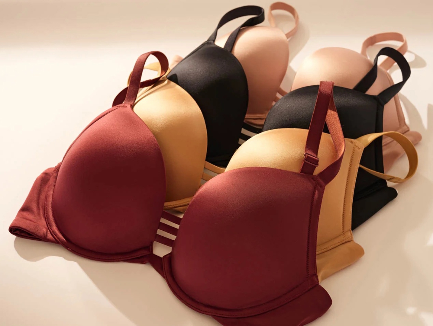 Soma<sup class=st-superscript>®</sup> laydown of nude, black, gold, and burgundy push-up bras for DD+ cup sizes.