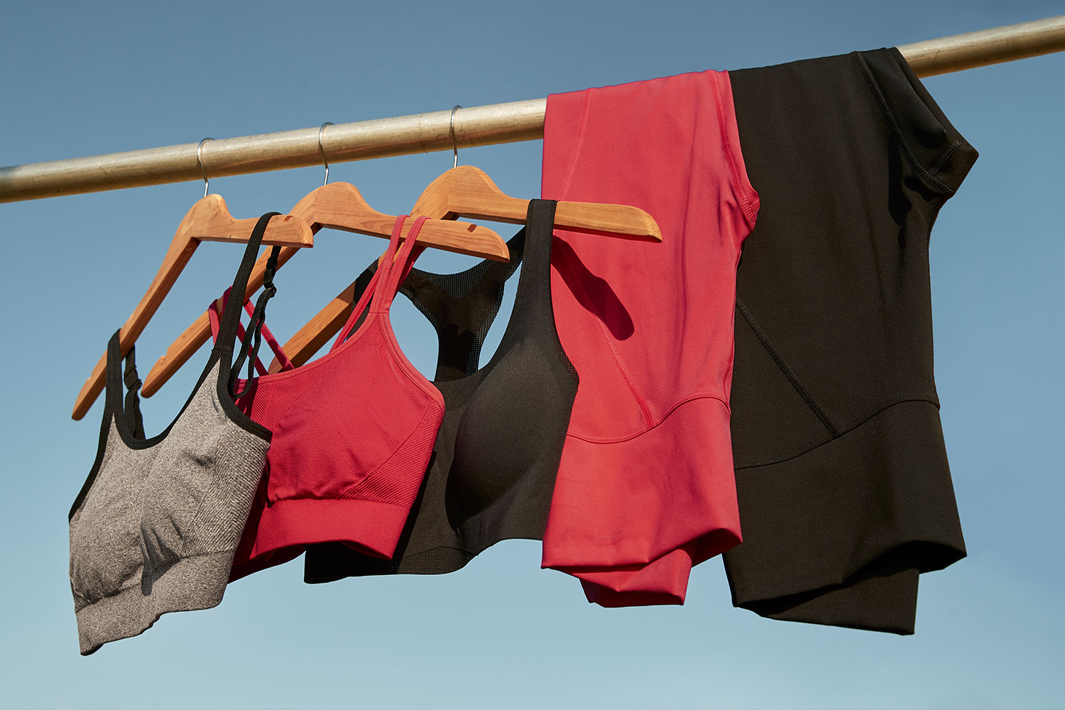 Soma<sup class=st-superscript>®</sup> women’s red and black sports bras and leggings hanging on a rack.