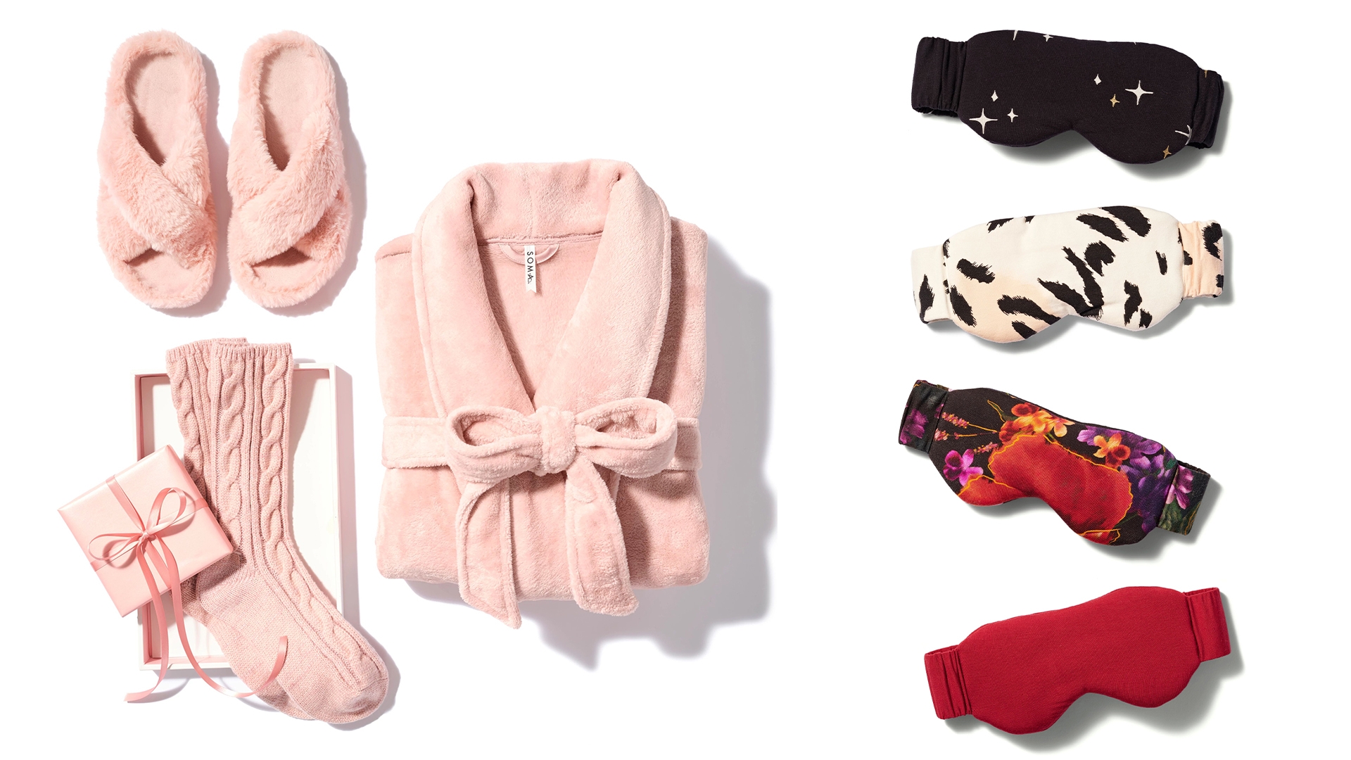 Soma<sup class=st-superscript>®</sup> laydown of light pink slippers, socks, gift box with ribbon, plush robe, and red, black floral, white animal print, and black star print sleep masks.
