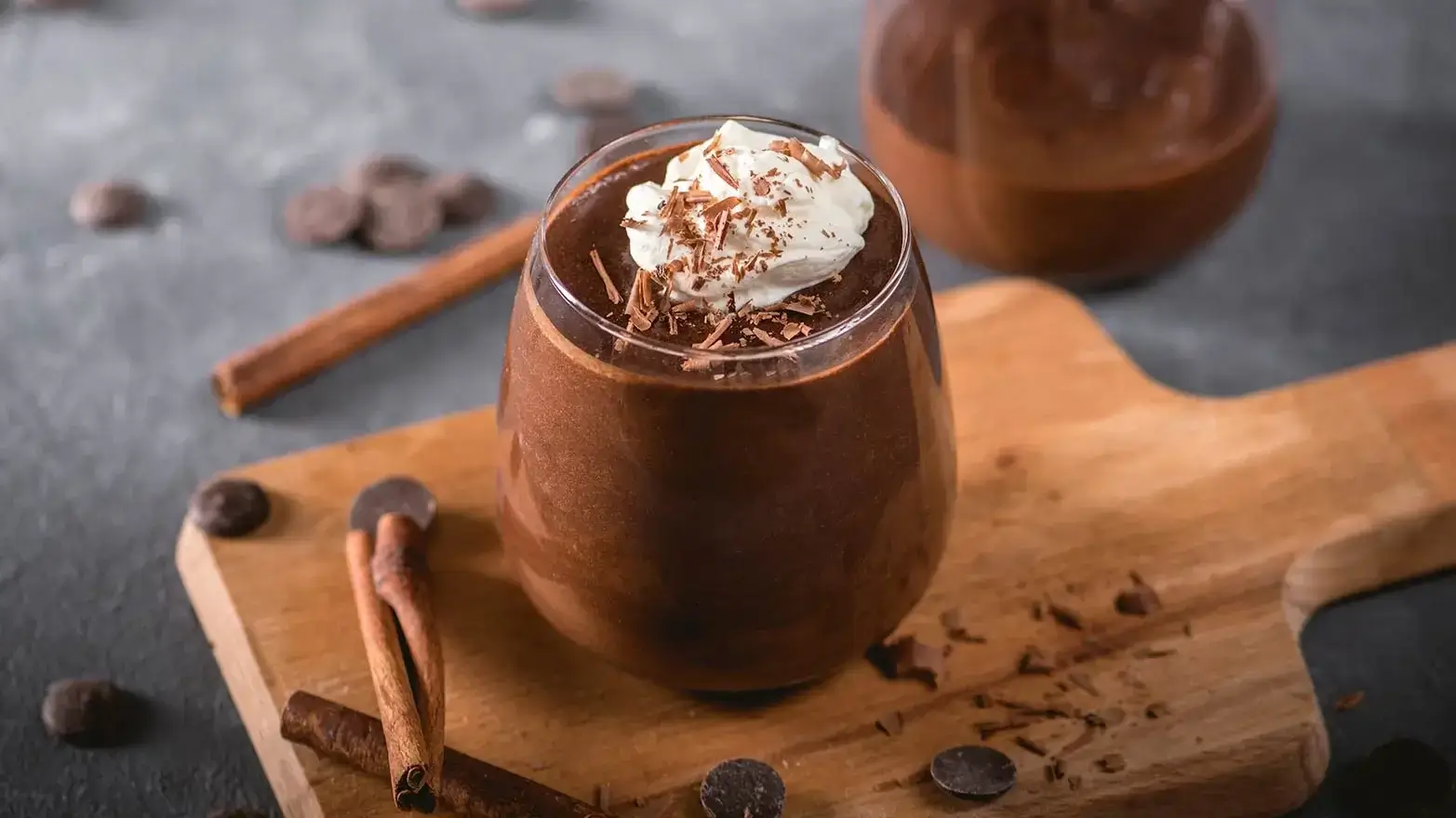 glass of chocolate pudding with whipped cream and chocolate shavings