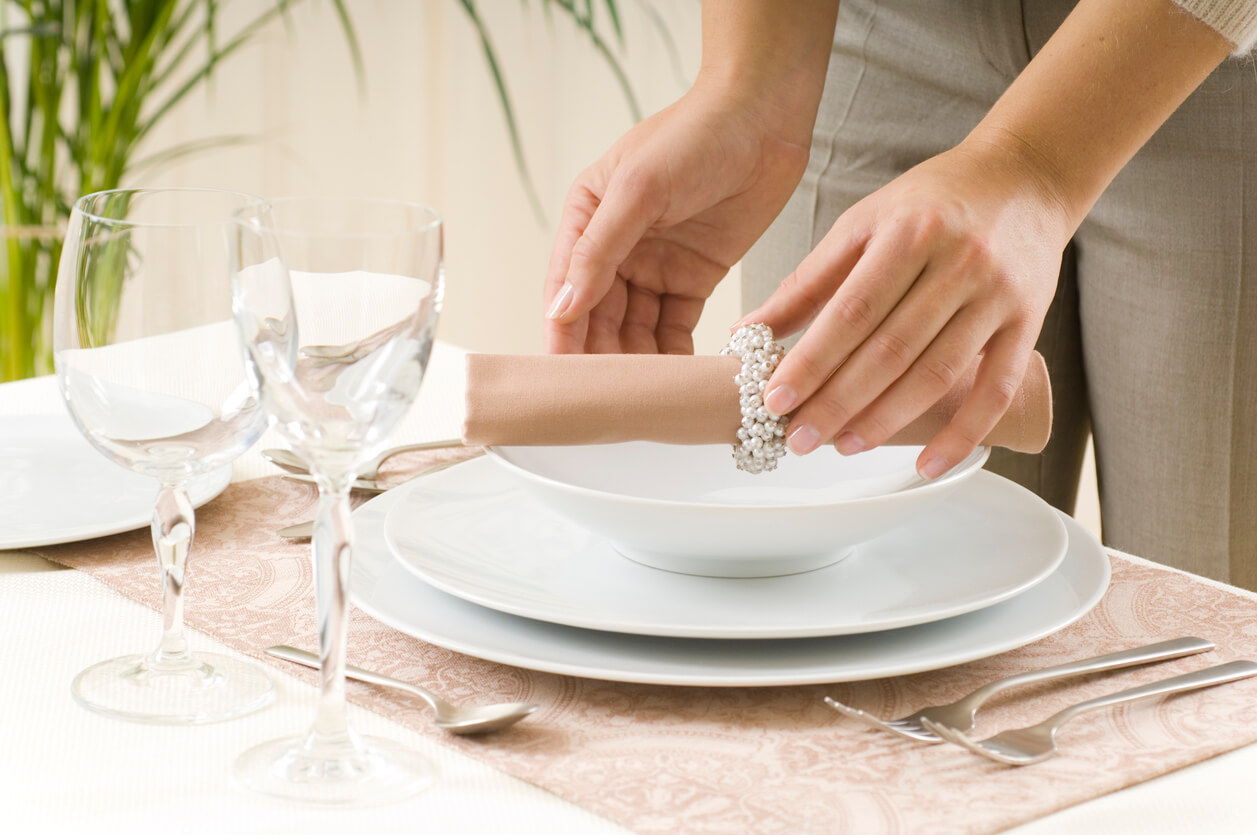Woman preparing a dinner table in horizontal composition
