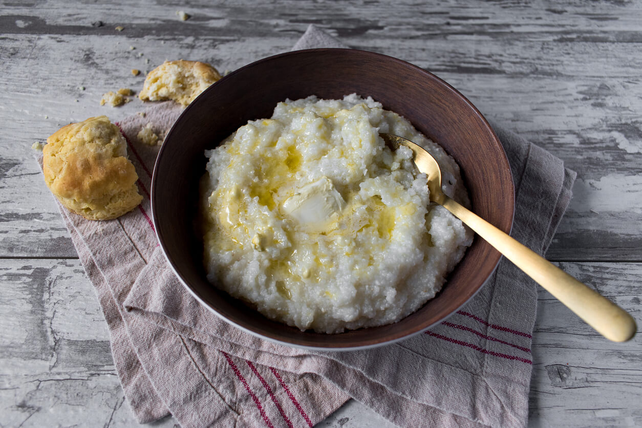 southern grits with biscuits and butter on rustic table top.