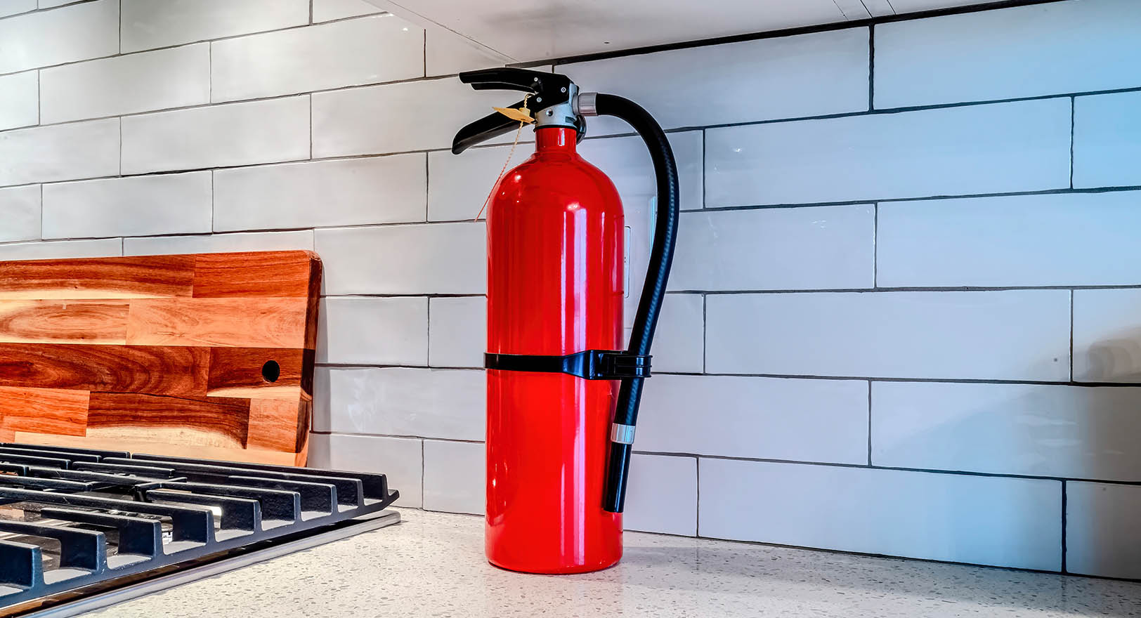 A photo of a red fire extinguisher on top of a kitchen counter.