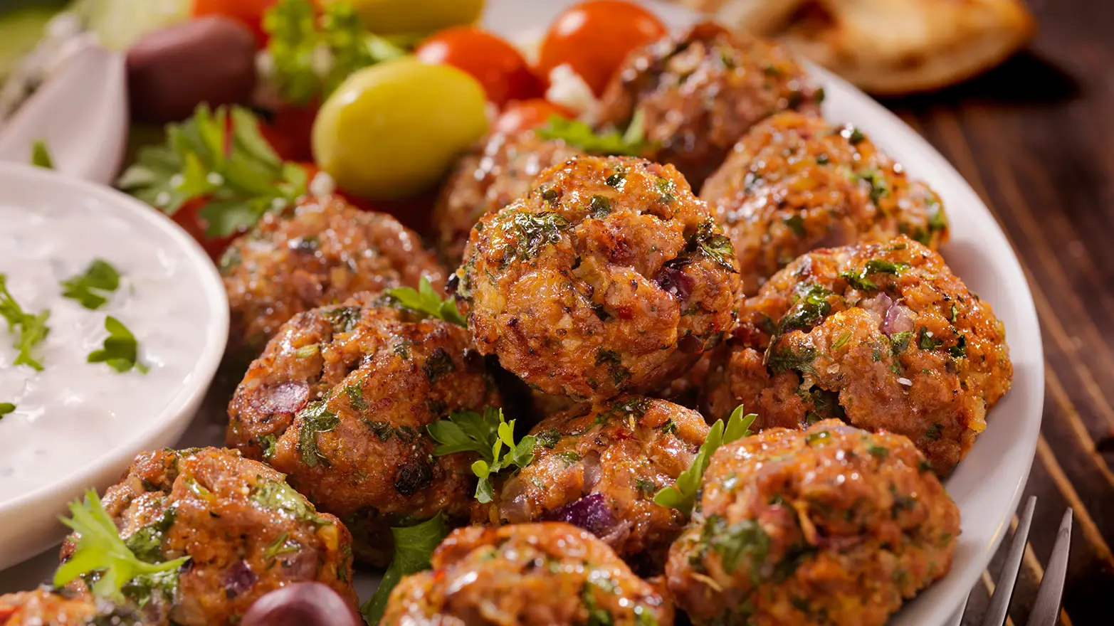 Greek meatballs garnished with fresh herbs.
