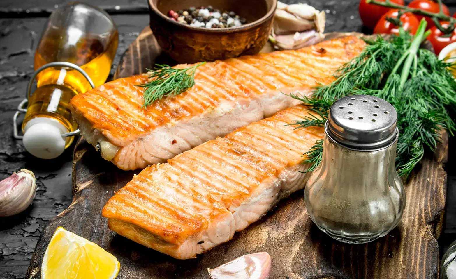 Cooked fish on a plate topped with fresh herbs.