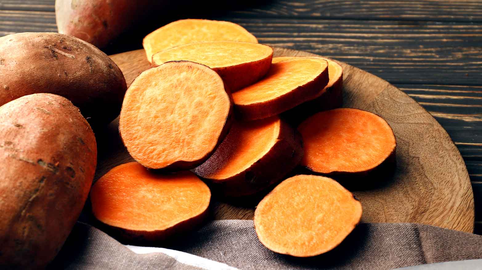 Sweet potatoes chopped up on a wooden cutting board