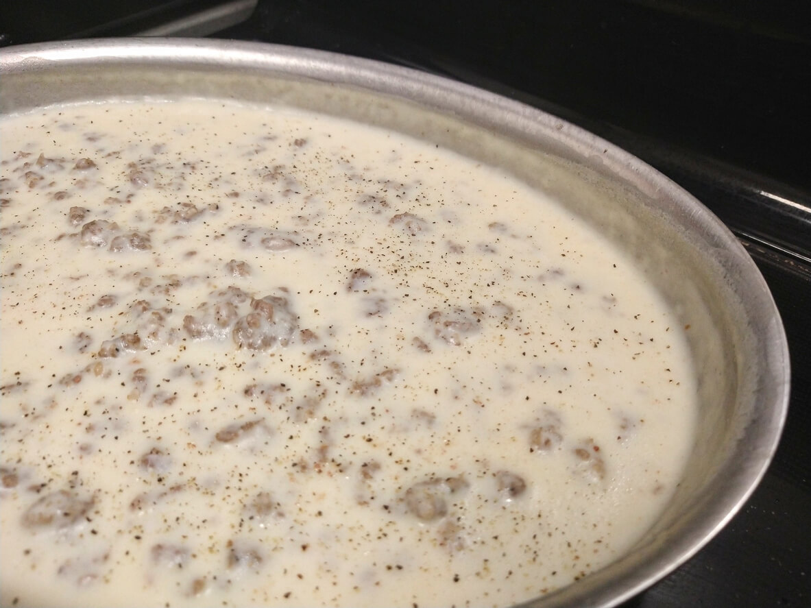 Brown sausage, add four tablespoons flour and three cups of milk, whisk over medium until thick.