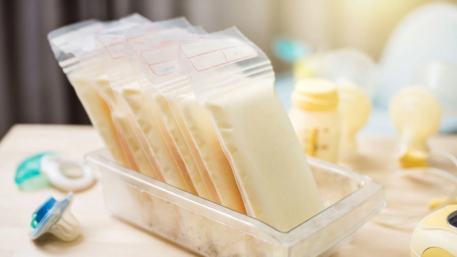 A stock photo of an assortment of nursing supplies and milk bags.