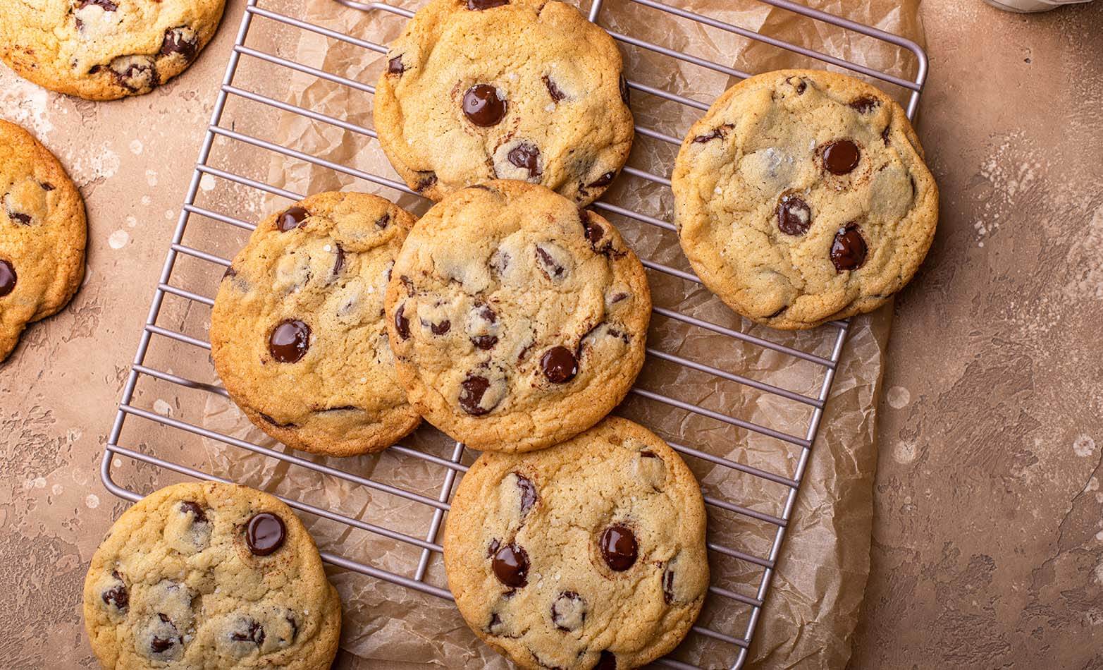 a batch of chocolate chip cookies on a cooling rack