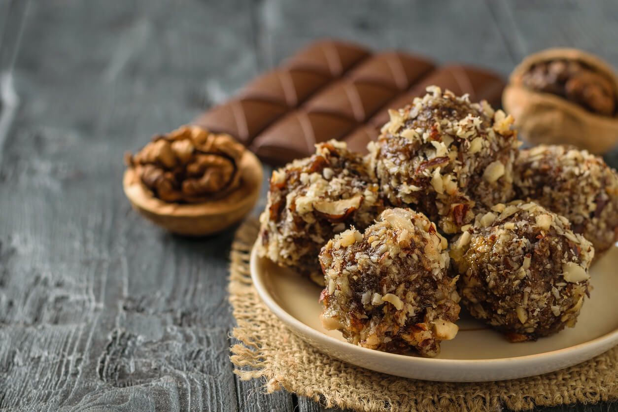 Hand-made balls of dried fruits, nuts and chocolate on a wooden table. Delicious fresh home-made candies.