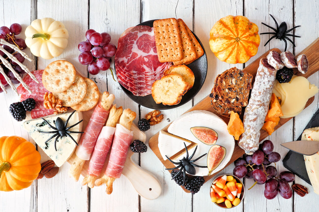 Halloween charcuterie table scene against a white wood background
