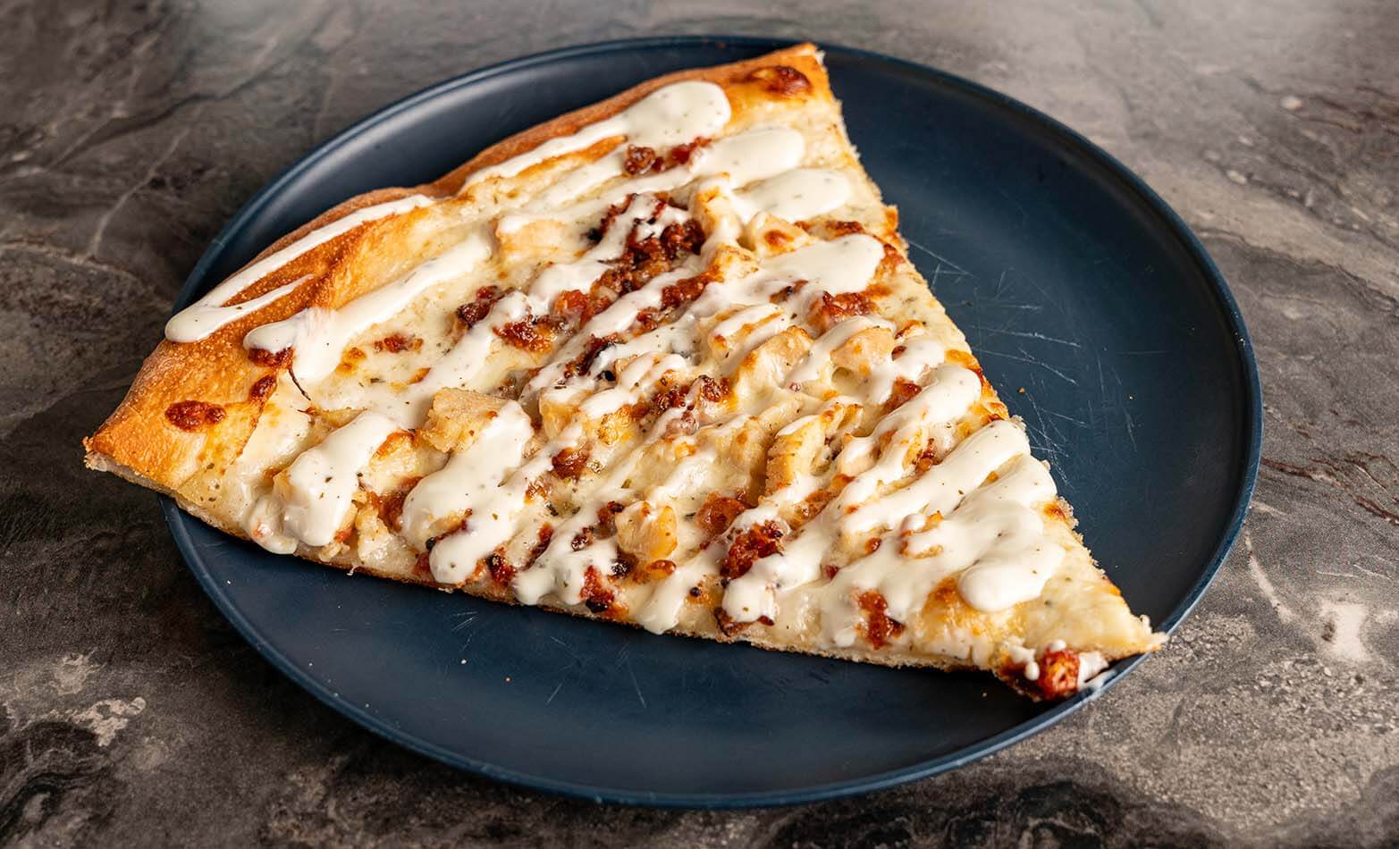 a slice of homemade chicken bacon ranch pizza on a plate