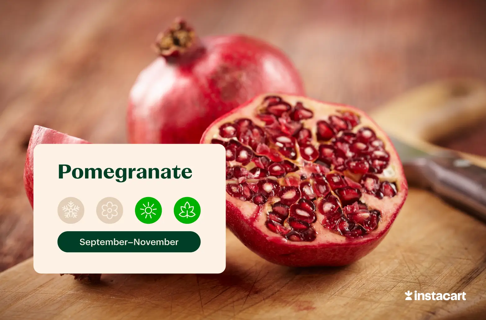 A whole pomegranate and an open pomegranate on a wooden surface.