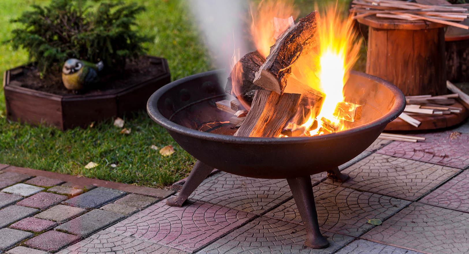 A photo of a small fire pit on a backyard patio.