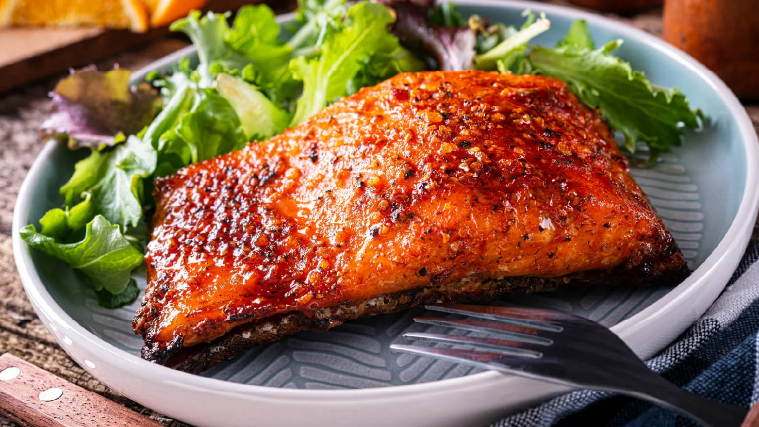 a photo of firecracker salmon on a plate with salad