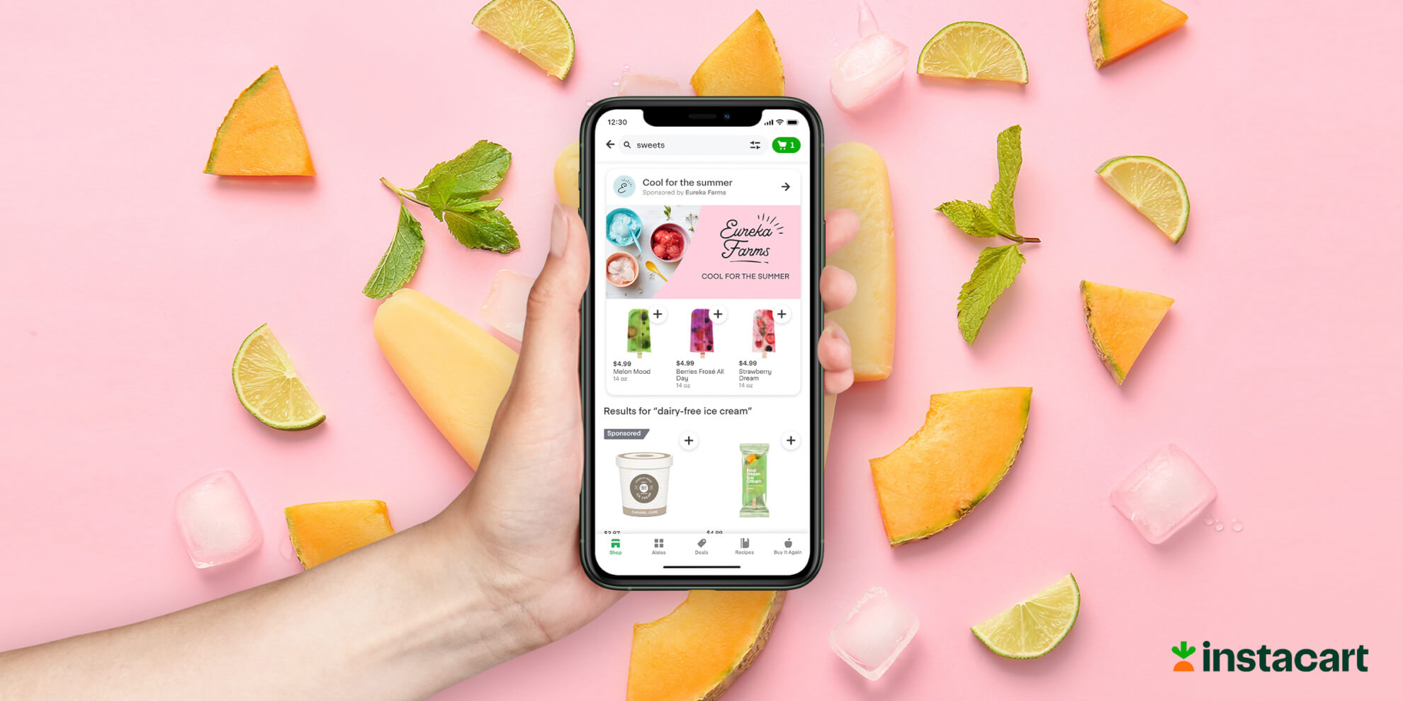 A person’s hand holds a smartphone with the Instacart platform shoppable ads displayed, on a pink background of fruits and popsicles.
