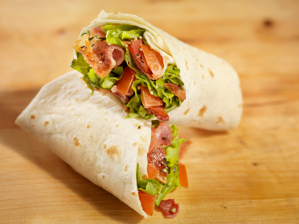 BLT Wrap Sandwich on a wooden board.