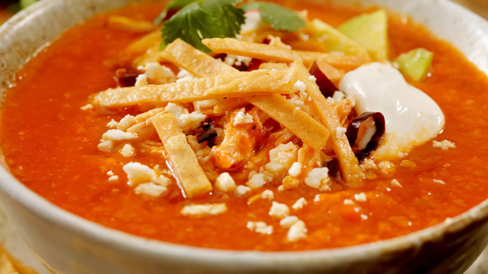 A close-up of a bowl of chicken tortilla soup.