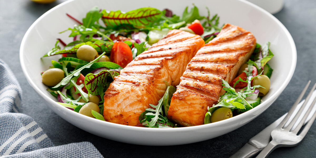 Grilled salmon fillet and fresh vegetable salad.