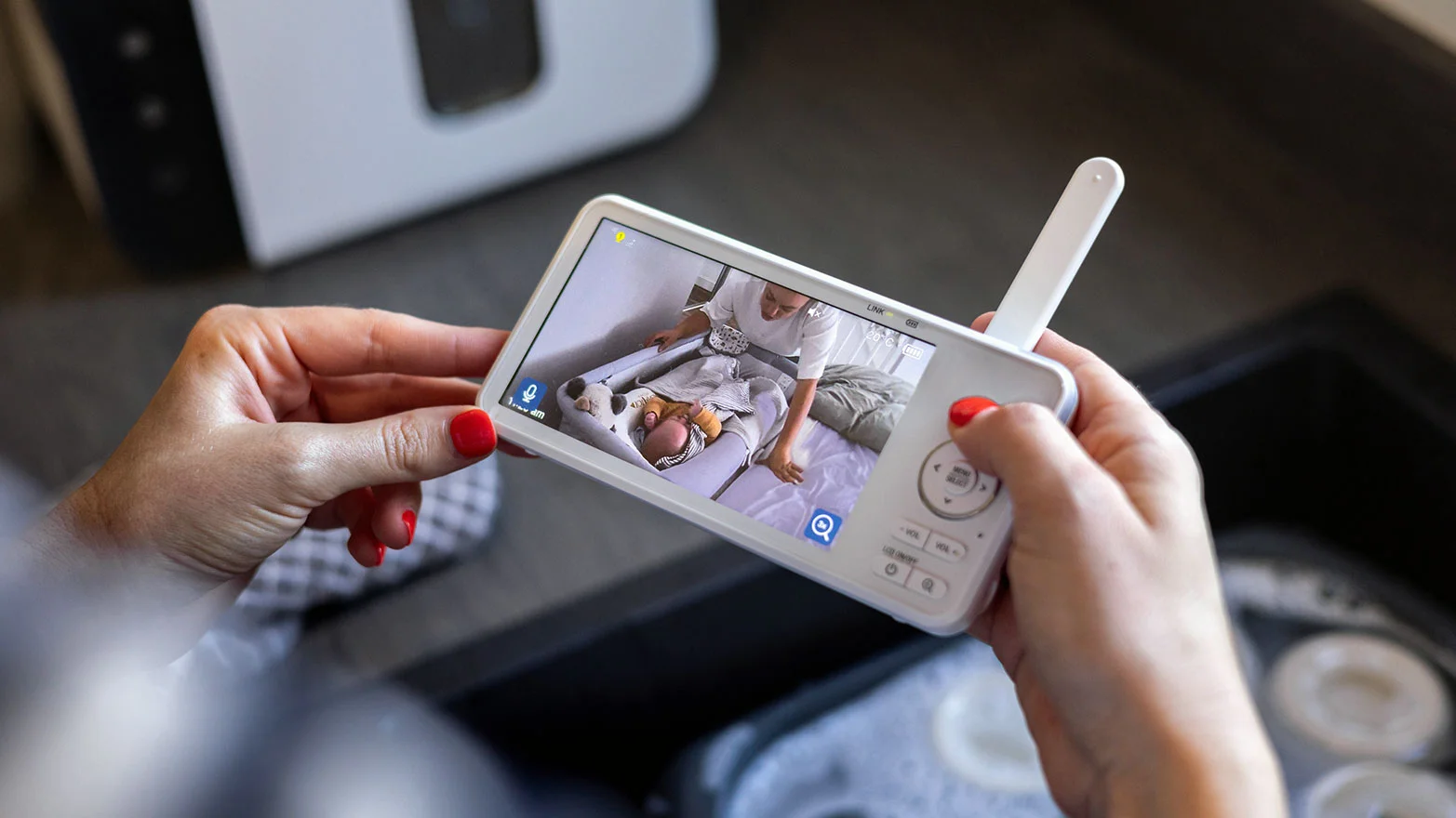 A close-up stock photo of a baby monitor in a woman’s hands.