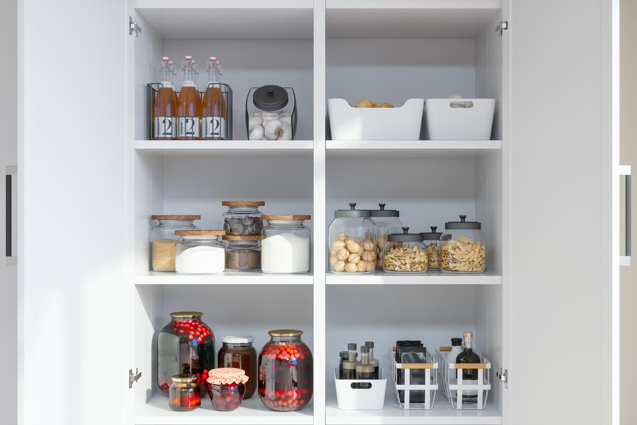 Organized Pantry Items With Variety of Nonperishable Food Staples And Preserved Foods in Jars On Kitchen Shelf.