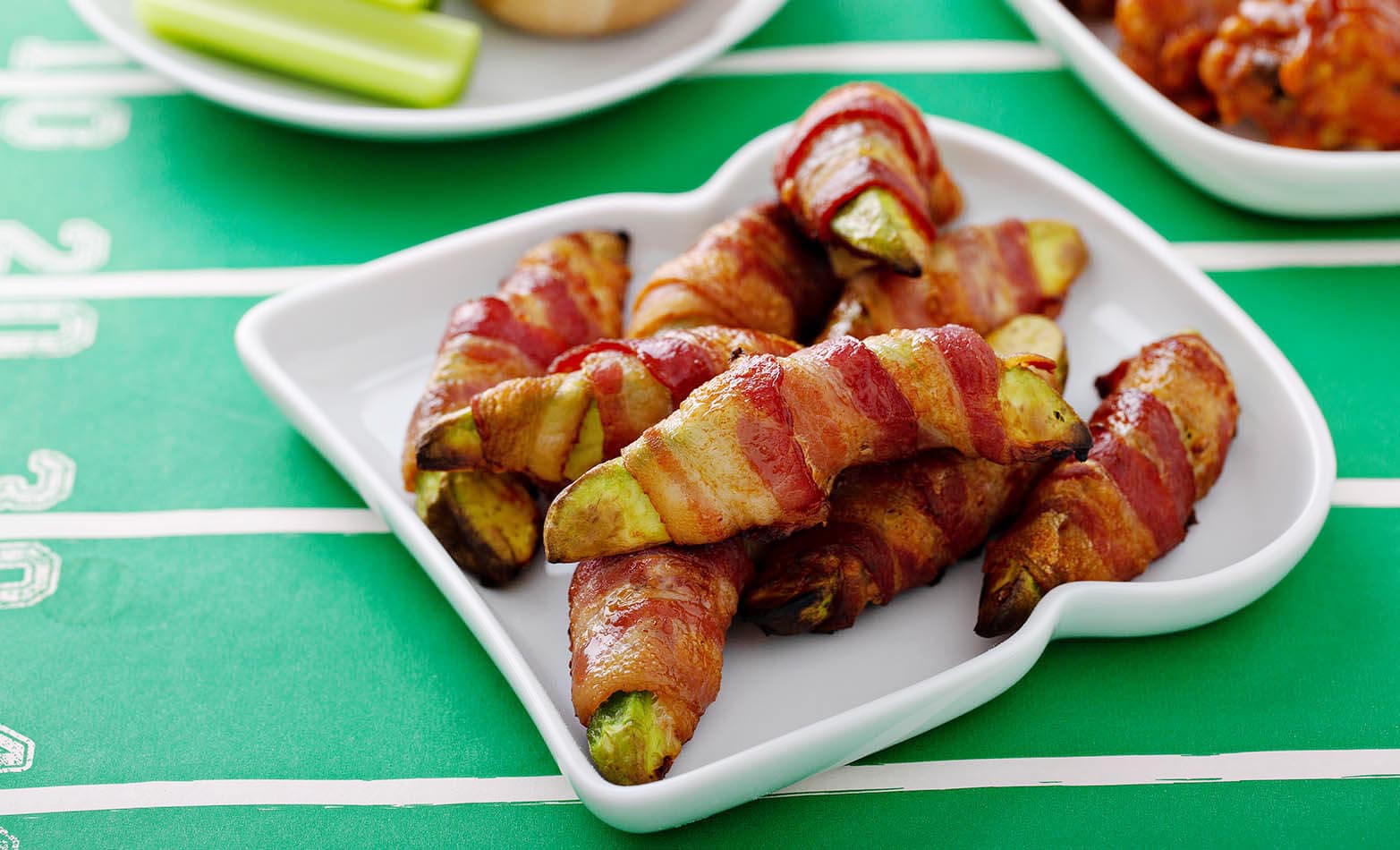 bacon wrapped avocado slices on a white plate