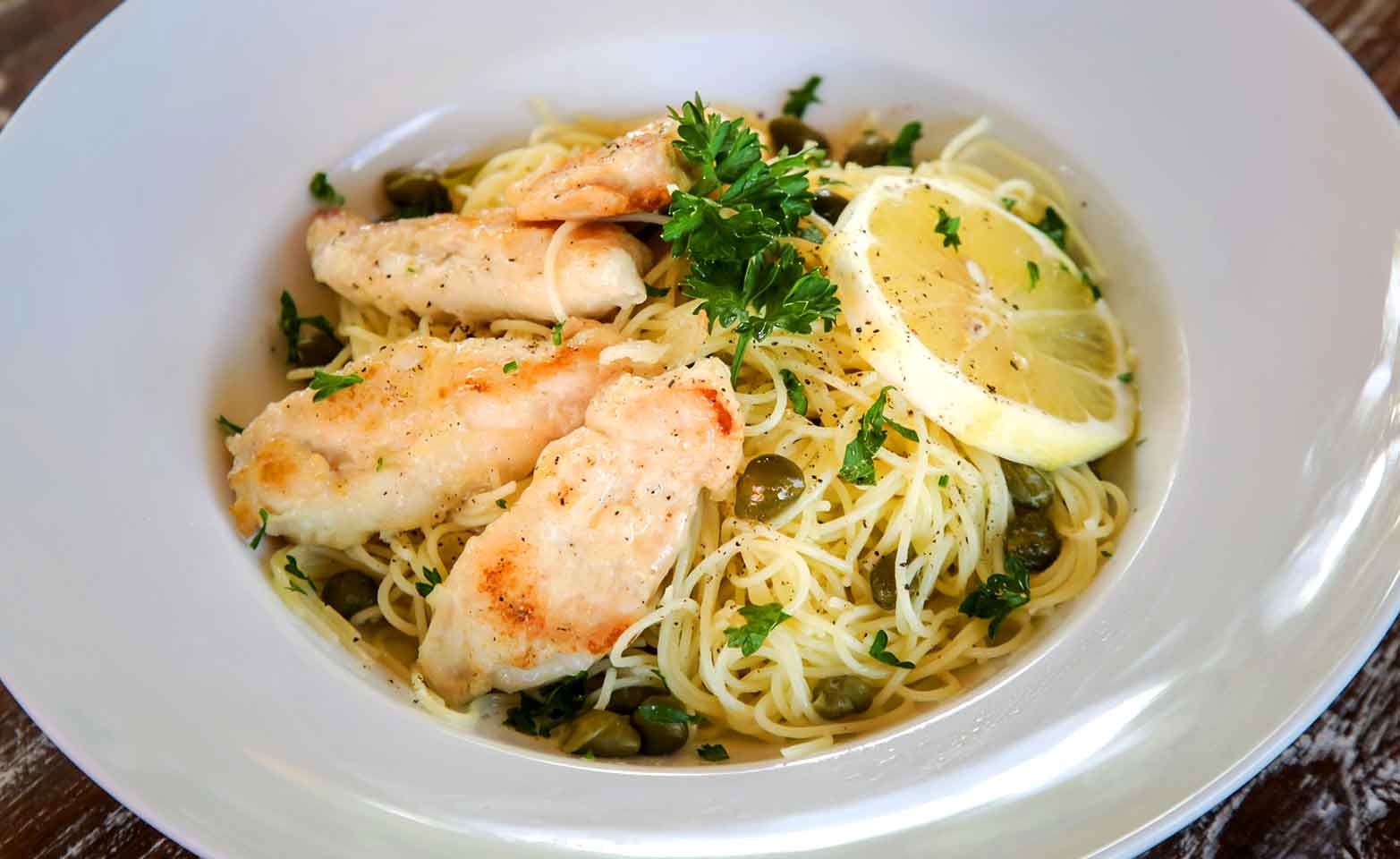 Stock image of chicken piccata with angel hair pasta