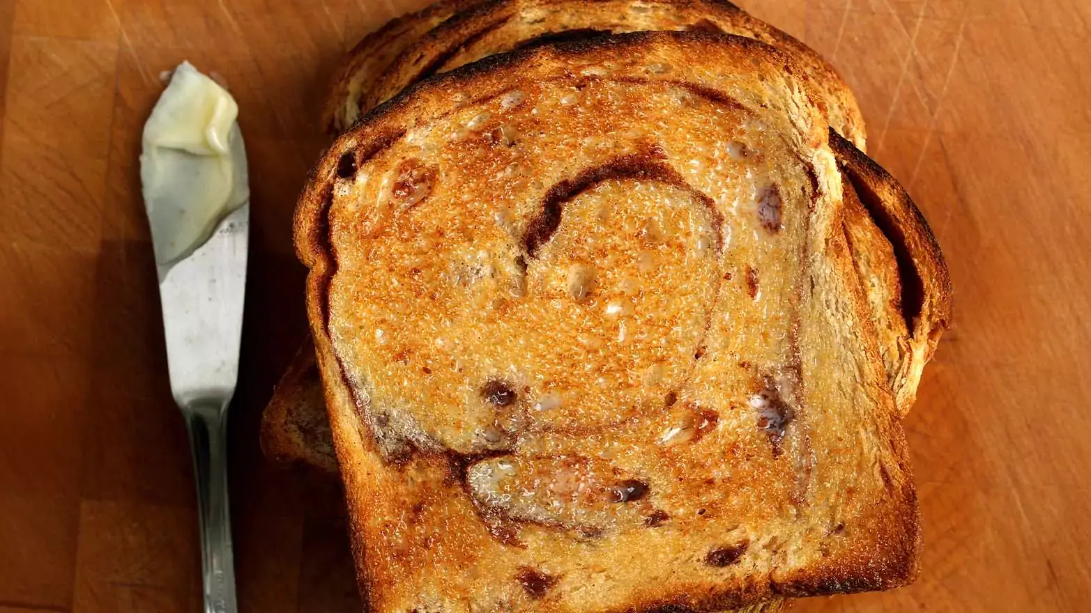 A buttered slice of cinnamon raisin bread