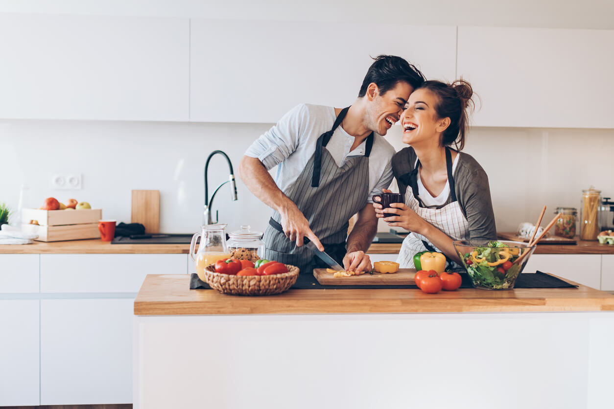 A couple cooks together in the kitchen.