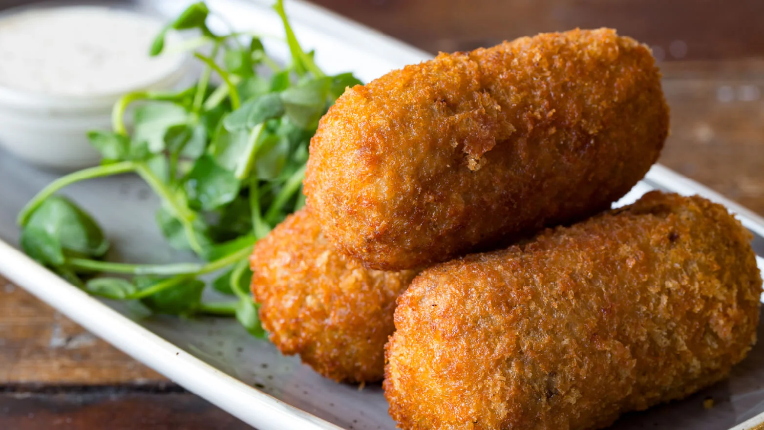 a photo of three salmon croquettes