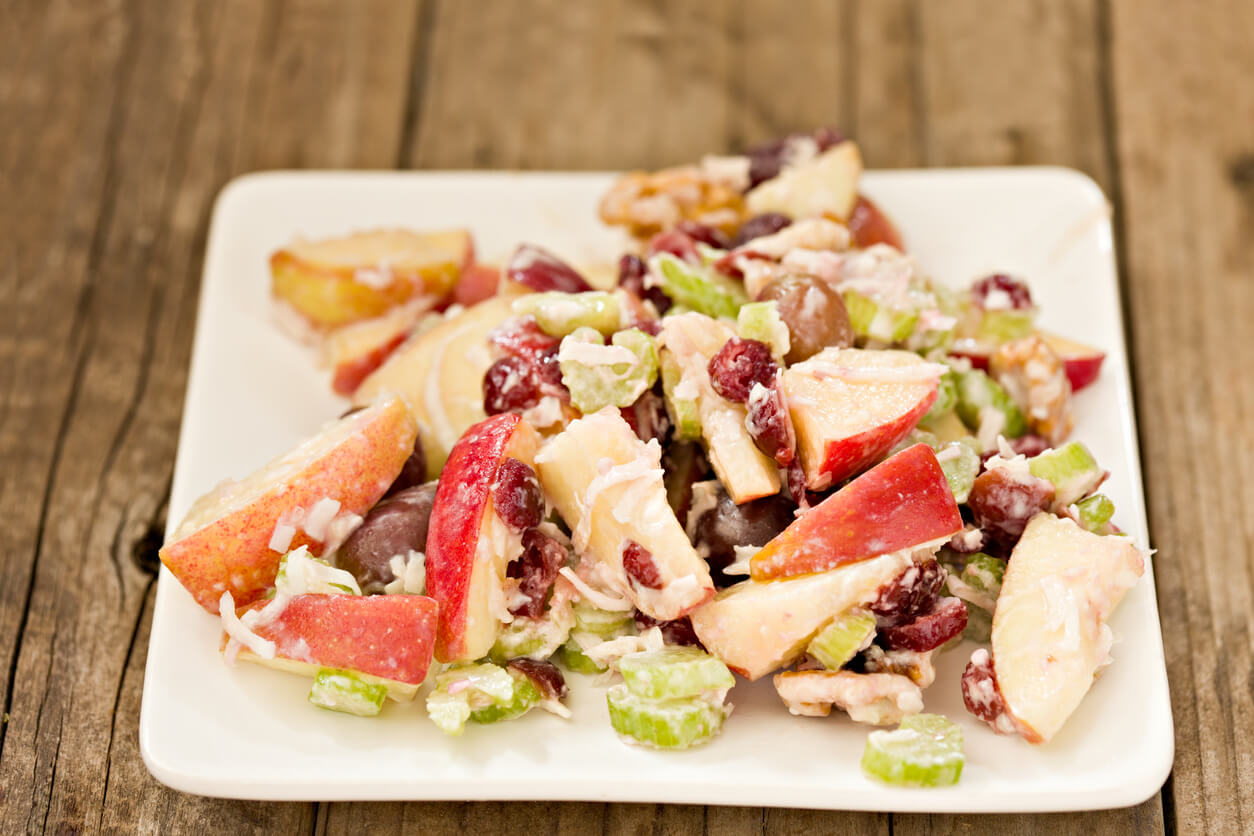 A high angle close up of a Waldorf salad on a white plate. 
