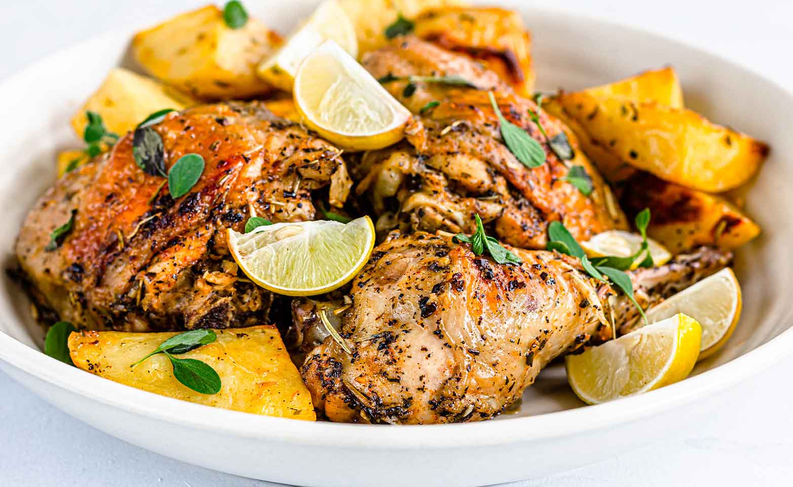 Stock image of grilled Greek chicken topped with lemons