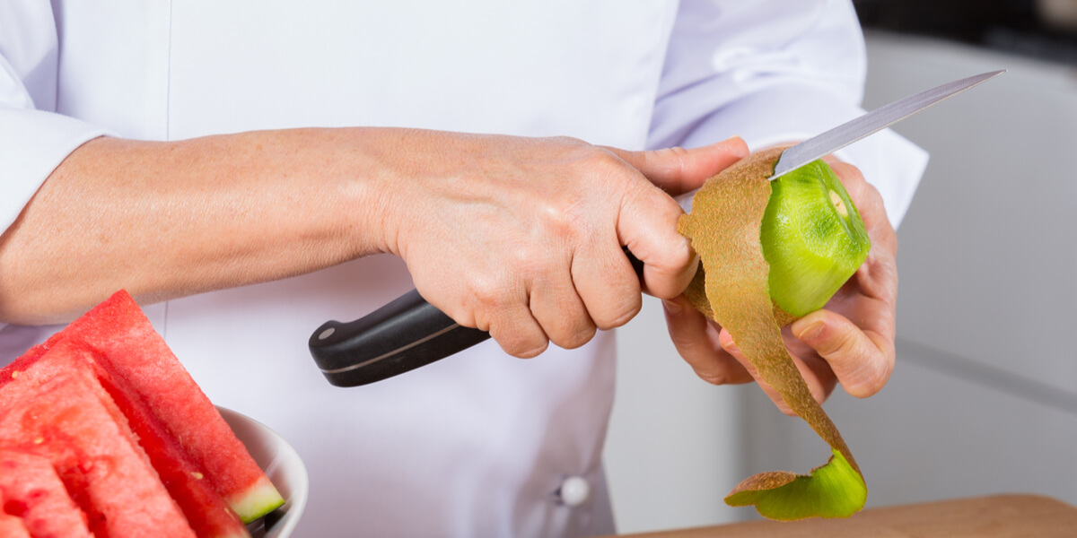 Peeling kiwis on a knife.