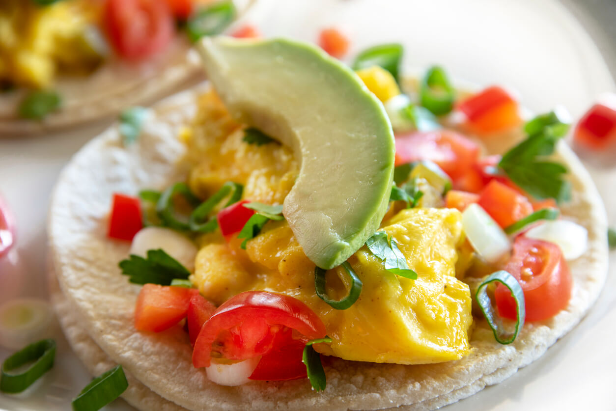 Two breakfast tacos on a white plate.