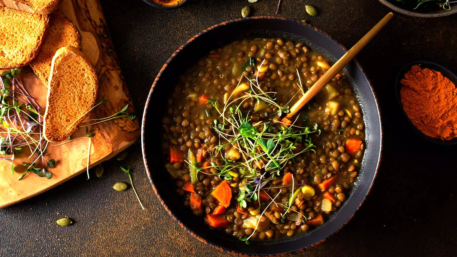 A bowl of vegan lentil soup served with bread.
