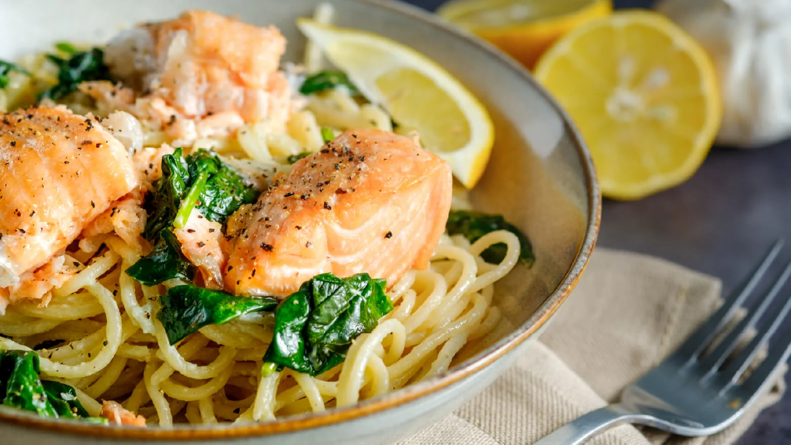 a photo of salmon pasta with spinach
