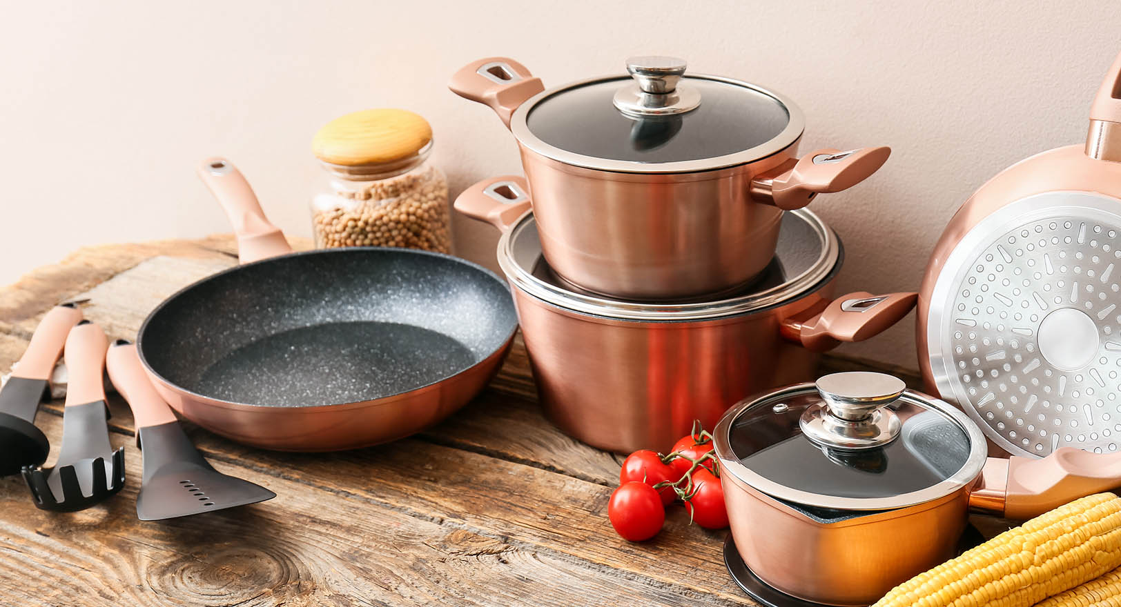 A photo of a stack of pots and pans on a wooden table.
